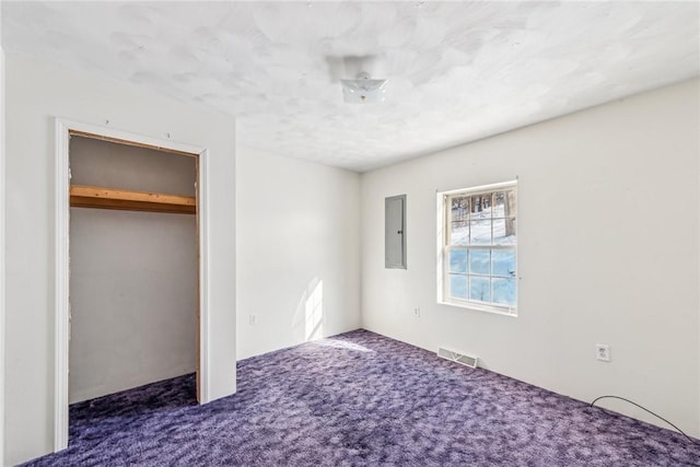 unfurnished bedroom featuring carpet floors, electric panel, and a closet