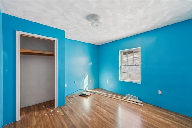 unfurnished bedroom with wood-type flooring and a closet