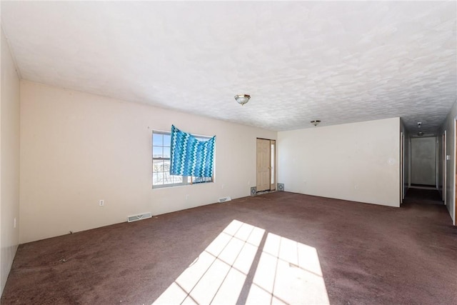 carpeted empty room with a textured ceiling