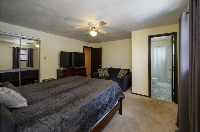 bedroom with ceiling fan, light colored carpet, ensuite bathroom, and a closet