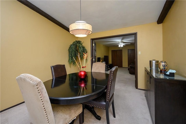 carpeted dining area with ceiling fan