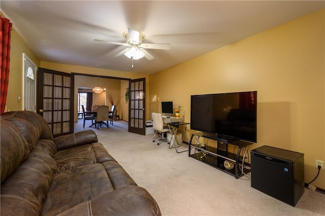 living room featuring ceiling fan, french doors, and light colored carpet