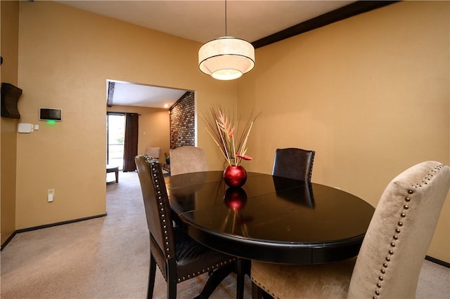 carpeted dining area with ornamental molding