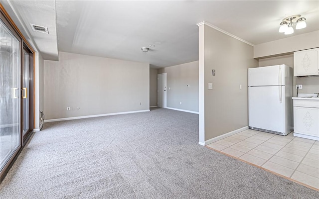 kitchen with white refrigerator, white cabinetry, and light carpet