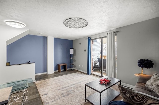 living room featuring vaulted ceiling, wood-type flooring, and a textured ceiling