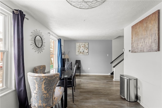 dining space with a textured ceiling and dark hardwood / wood-style floors