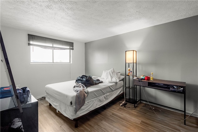 bedroom featuring hardwood / wood-style floors and a textured ceiling