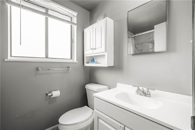 bathroom featuring vanity, curtained shower, and toilet