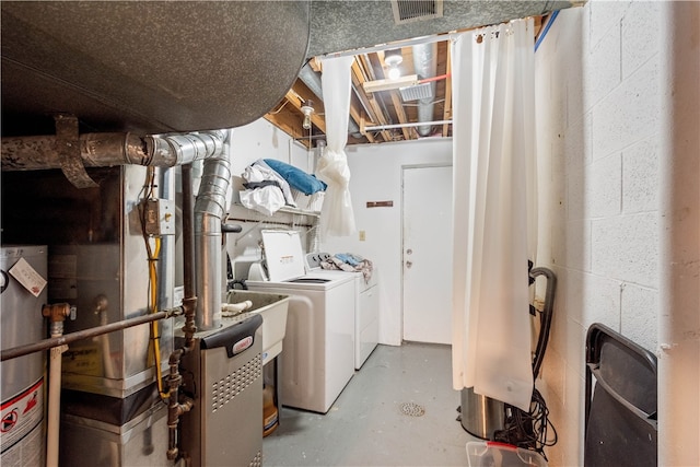 laundry room featuring water heater and independent washer and dryer