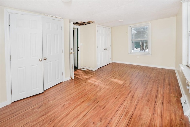 unfurnished bedroom featuring a textured ceiling and light hardwood / wood-style flooring