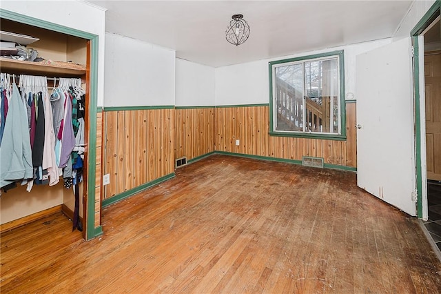 spare room with wood walls and wood-type flooring