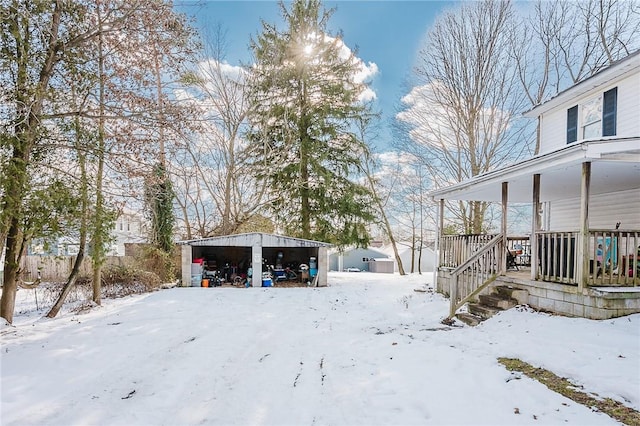 yard layered in snow with a carport