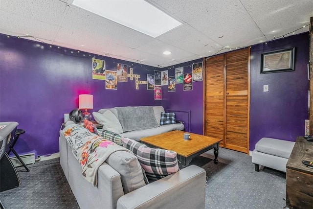 living room featuring a drop ceiling and a baseboard radiator