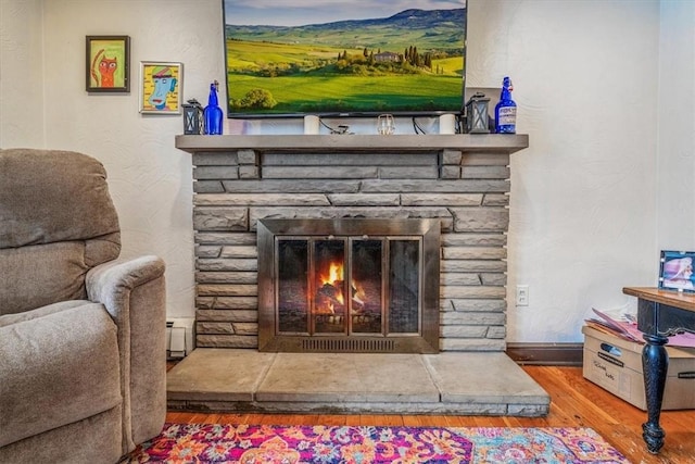 interior details featuring a fireplace, wood-type flooring, and a baseboard radiator