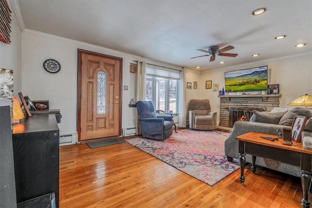 living room featuring hardwood / wood-style floors, baseboard heating, and ceiling fan