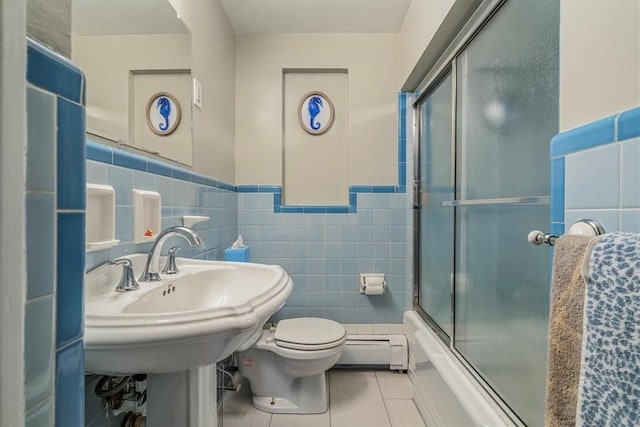 full bathroom with a baseboard heating unit, combined bath / shower with glass door, tile patterned flooring, toilet, and tile walls