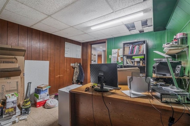 office area featuring a drop ceiling and wooden walls