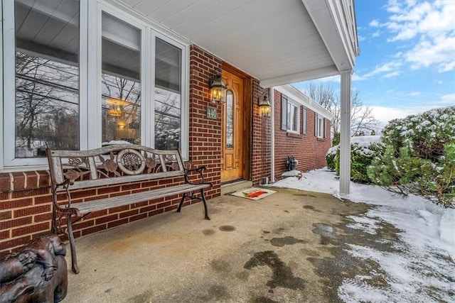 snow covered patio featuring covered porch