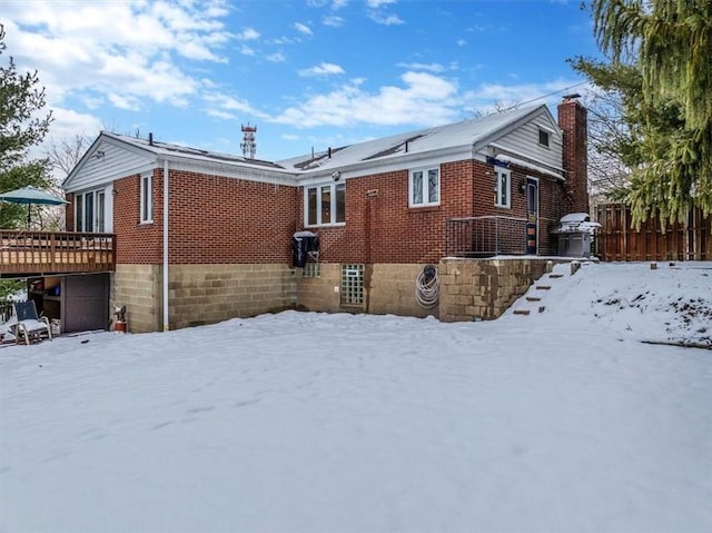 view of snowy exterior featuring a deck