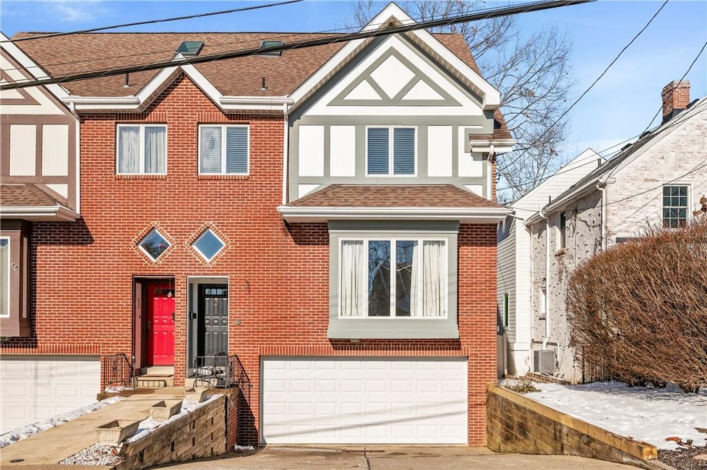 view of front of property featuring a garage and central AC