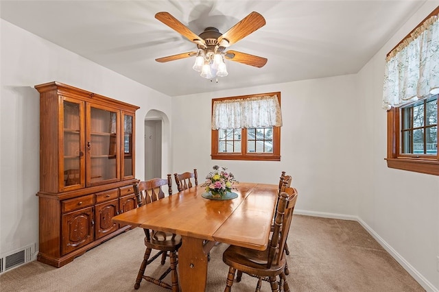 dining space featuring light carpet and ceiling fan