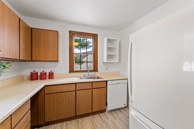 kitchen with light hardwood / wood-style floors, white appliances, and sink