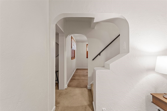 hallway featuring light colored carpet