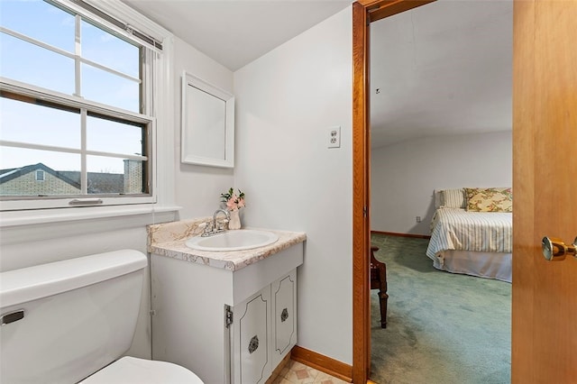 bathroom featuring vanity, a healthy amount of sunlight, toilet, and vaulted ceiling