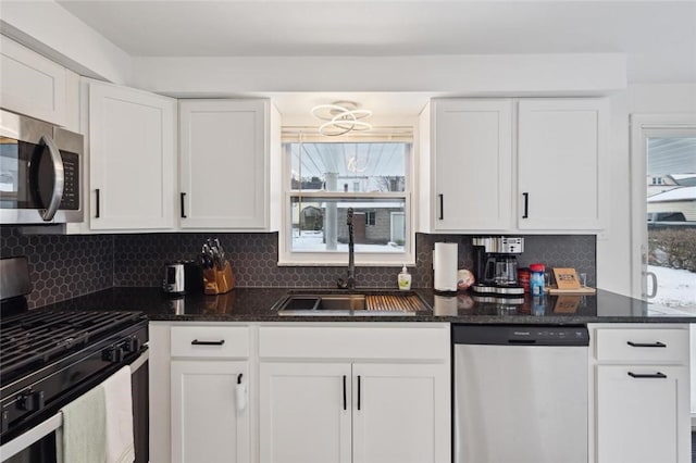 kitchen with white cabinets, sink, appliances with stainless steel finishes, and tasteful backsplash