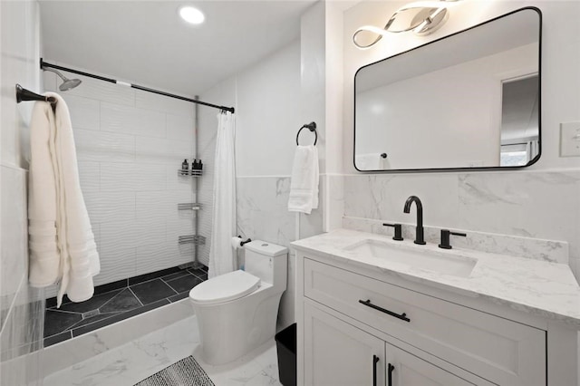 bathroom with vanity, toilet, tile walls, and walk in shower