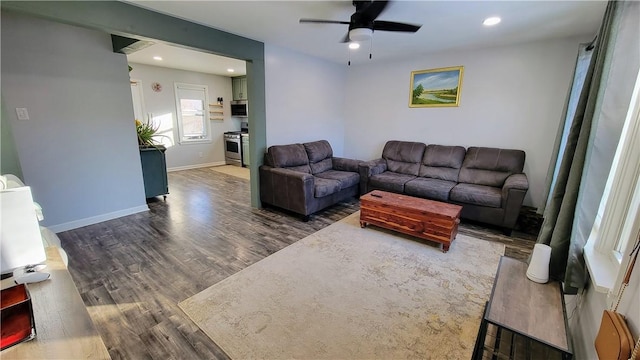 living room with dark hardwood / wood-style flooring and ceiling fan