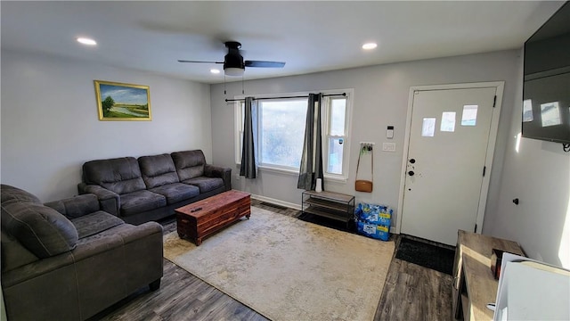 living room featuring ceiling fan and dark hardwood / wood-style floors