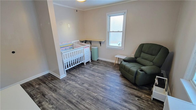 bedroom with a nursery area, ornamental molding, and dark hardwood / wood-style flooring