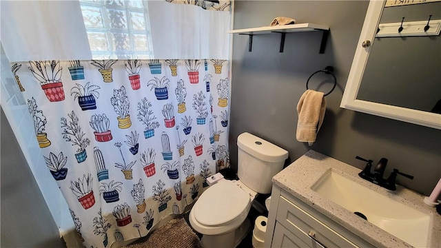 bathroom featuring curtained shower, vanity, and toilet