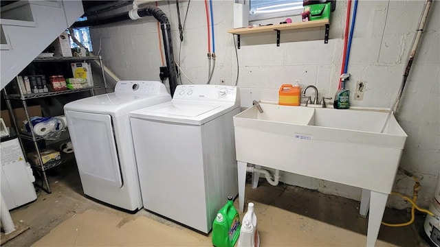 clothes washing area with washer and clothes dryer and sink