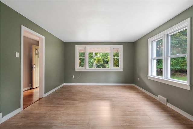 unfurnished room with light wood-type flooring and plenty of natural light