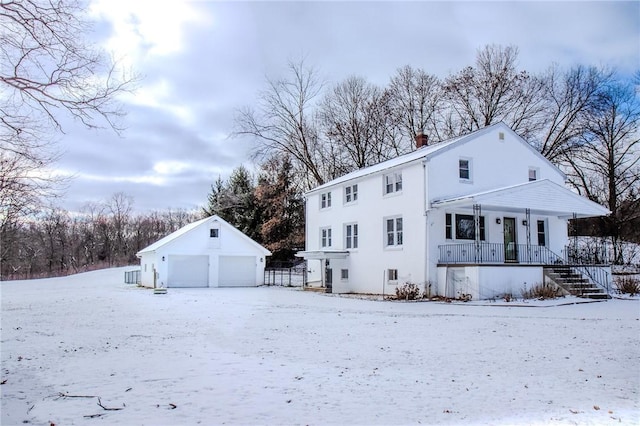 exterior space featuring a garage, a porch, and an outdoor structure