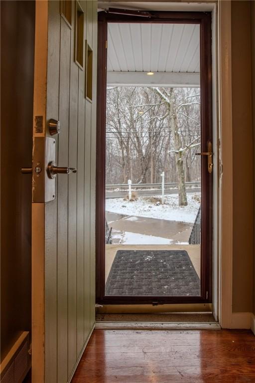 doorway to outside with wooden walls and hardwood / wood-style flooring