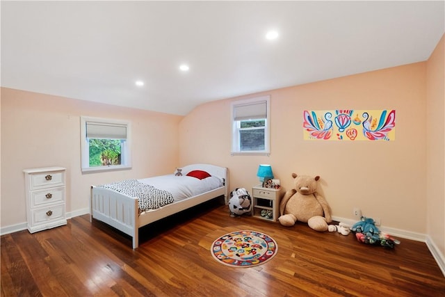 bedroom with dark wood-type flooring, vaulted ceiling, and multiple windows