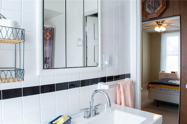 bathroom with tile walls, ceiling fan, and sink