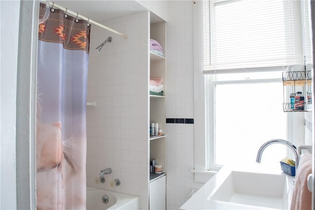 bathroom with sink, shower / bathtub combination with curtain, and plenty of natural light