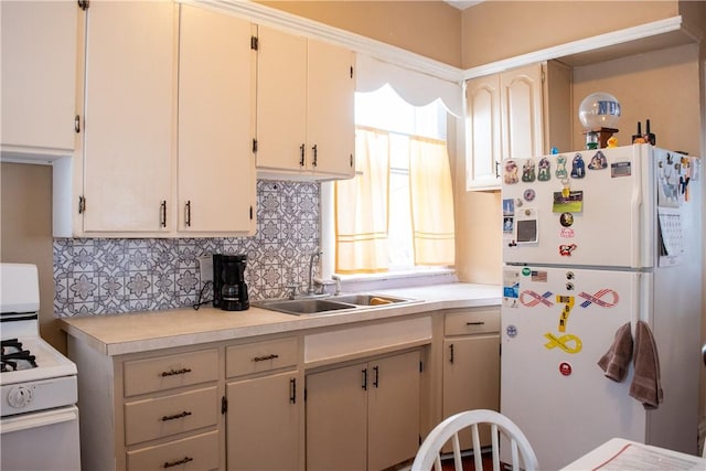 kitchen with white appliances, cream cabinetry, backsplash, and sink