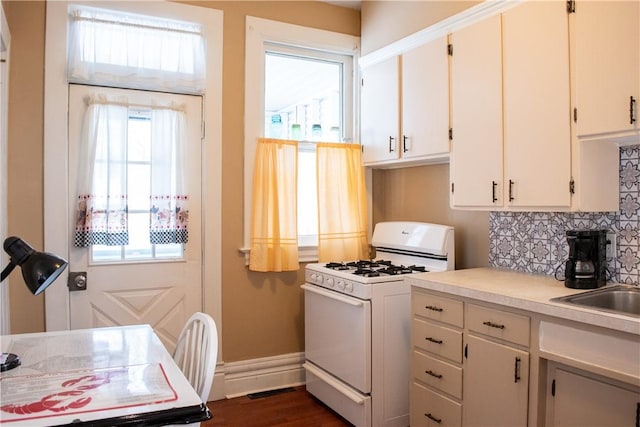 kitchen with tasteful backsplash, white cabinetry, a wealth of natural light, and white gas stove