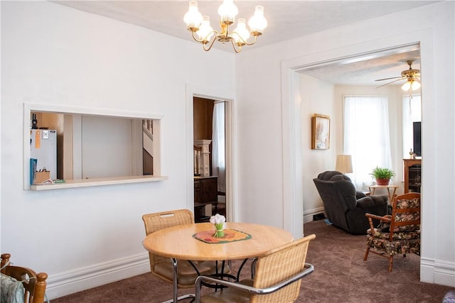 carpeted dining space with ceiling fan with notable chandelier