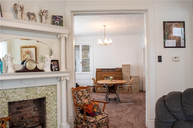 dining room featuring a notable chandelier, a tile fireplace, and carpet flooring