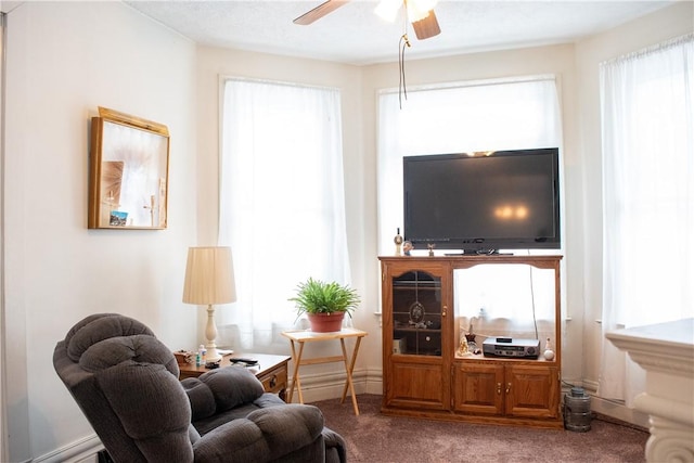 living room featuring a wealth of natural light, ceiling fan, and carpet flooring