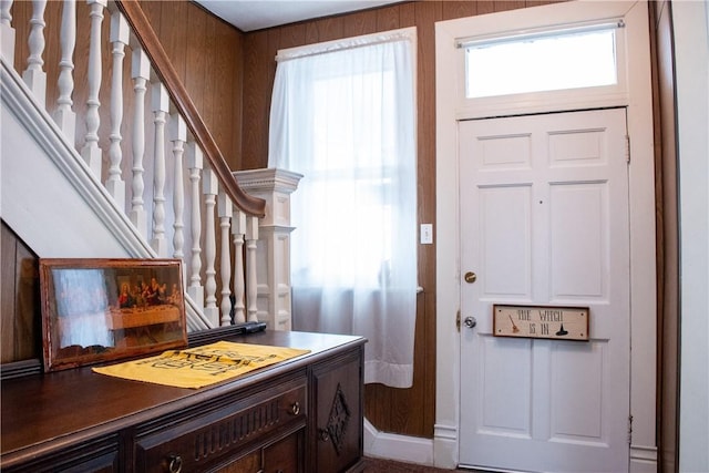 foyer entrance featuring wooden walls