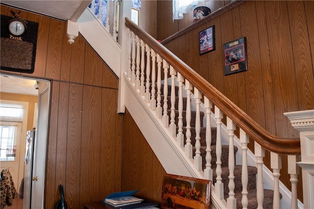 stairs featuring wood walls