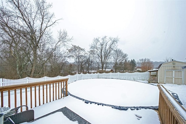 yard layered in snow featuring a storage unit