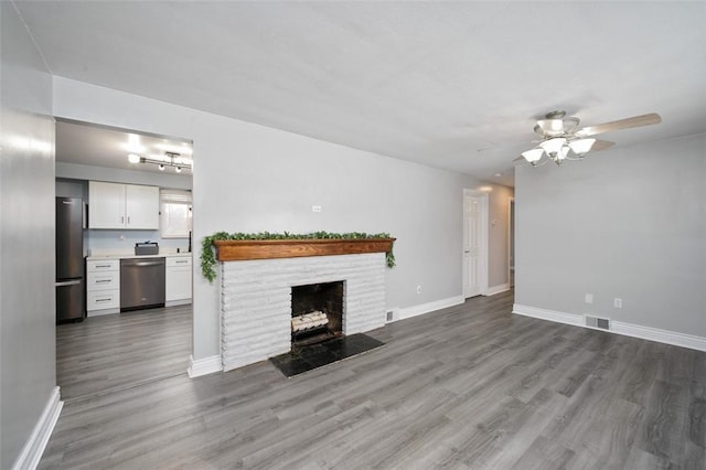 unfurnished living room with ceiling fan, a fireplace, and hardwood / wood-style flooring